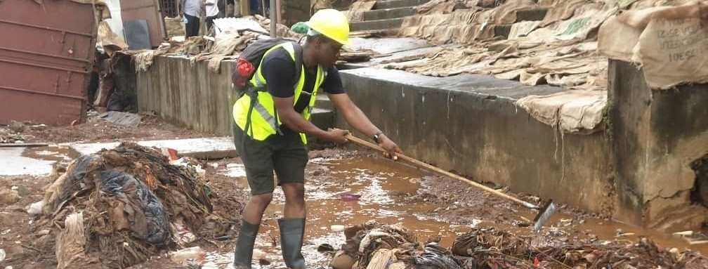 A senior worker of Freetown City Council doing cleaning of the rubbish from clogged up gutters during the rains in July 2023 in Freetown. 
Credit: eco-talk/Hassan I.Conteh
