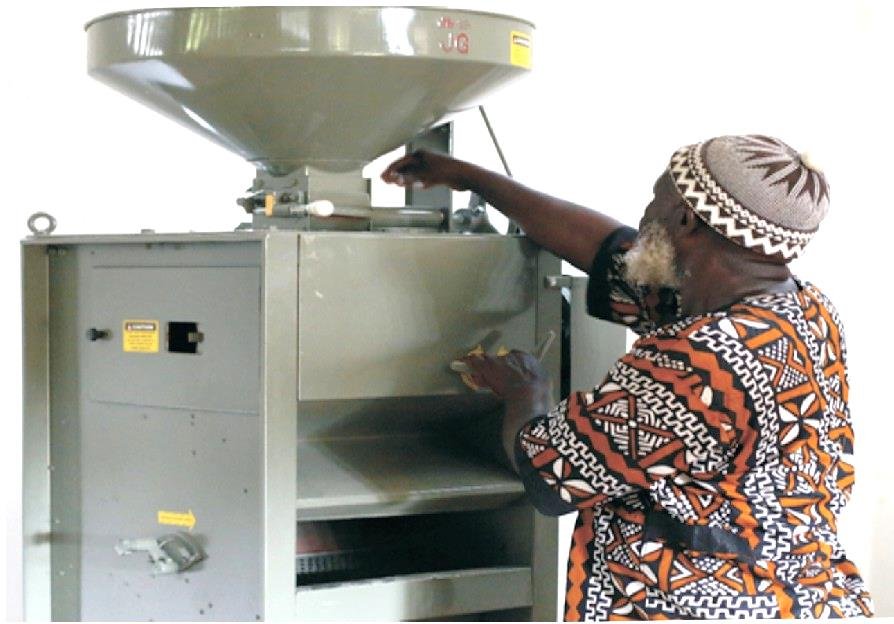 Chief Shieku Koroma of Sierra Euro Opportunity and Rural Enterprise Development Farmers Association at Yawei Village, Bum Chiefdom in the Bonthe district inspecting a newly installed rice mill provided to them by SCADeP